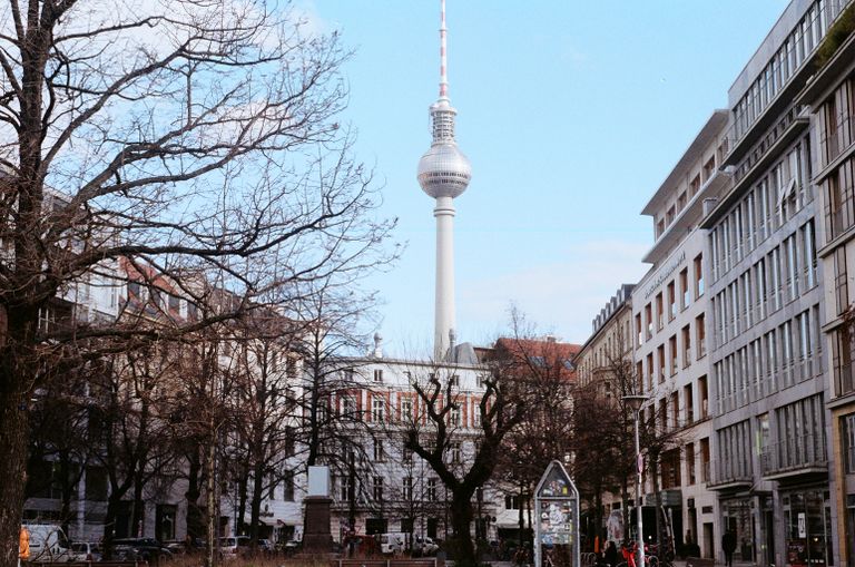 A clear view of the Berlin TV Tower surrounded by urban buildings, illustrating the vibrant city life.